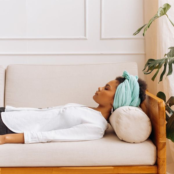 Peaceful woman meditating in lotus position with soft lighting.